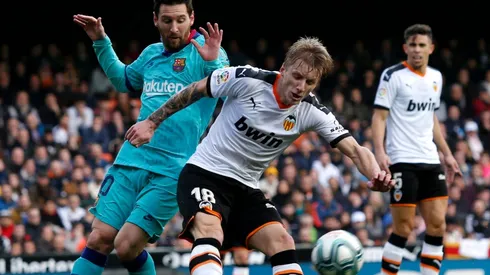 Daniel Wass of Valencia (right) battles for possession with Lionel Messi of FC Barcelona (left). (Getty)