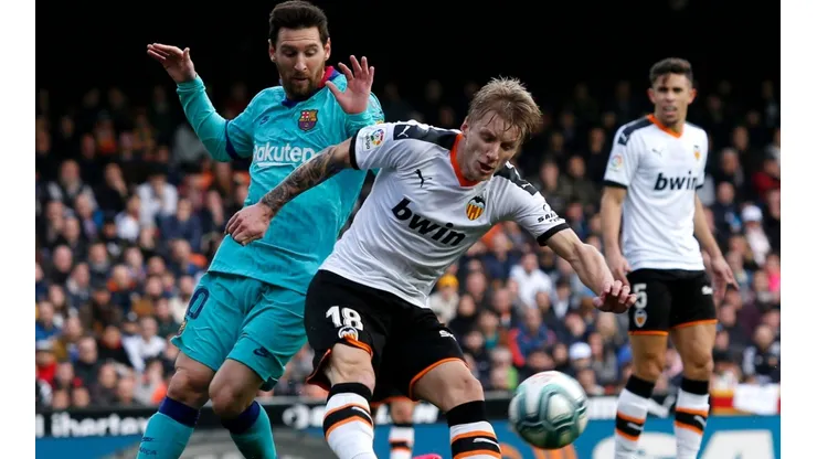 Daniel Wass of Valencia (right) battles for possession with Lionel Messi of FC Barcelona (left). (Getty)