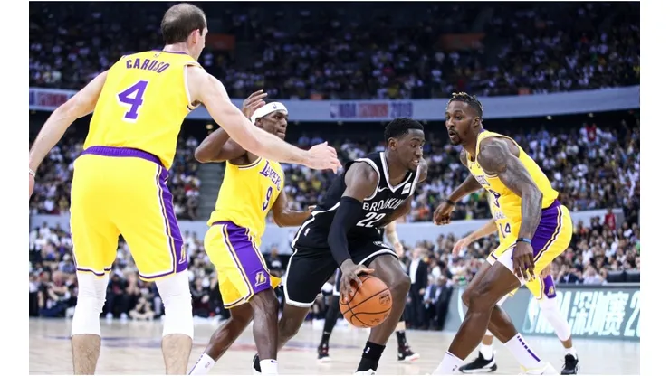 Alex Caruso, Rajon Rondo, and Dwight Howard guarding Nets' Caris LeVert. (Getty)