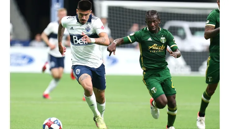 Vancouver Whitecaps forward Joaquin Ardaiz (left) runs the ball away from Portland Timbers midfielder Diego Chara (right. (Getty)