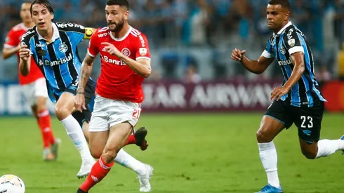 Boschilia of Internacional kicks the ball against Jeromel and Alisson of Gremio during the match for the Copa CONMEBOL Libertadores 2020