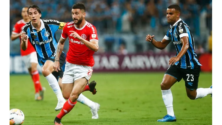 Boschilia of Internacional kicks the ball against Jeromel and Alisson of Gremio during the match for the Copa CONMEBOL Libertadores 2020