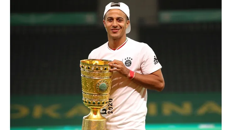 Thiago Alcantara of FC Bayern Muenchen poses with the trophy in celebration after the DFB Cup