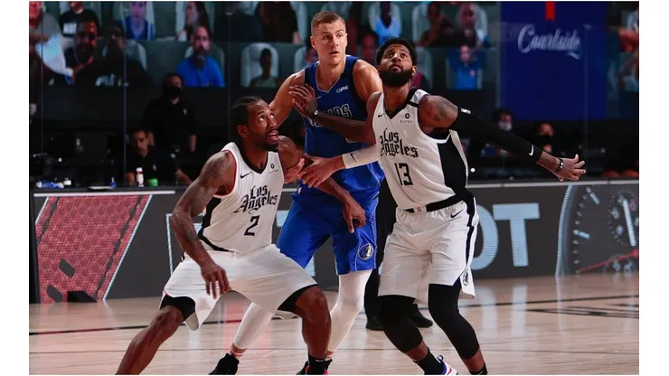 Kawhi Leonard and Paul George boxing out Kristaps Porzingis. (Getty)