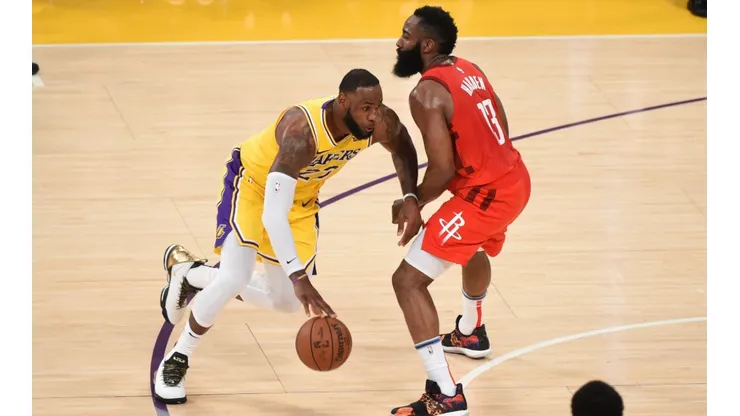 LeBron James dribbling past James Harden. (Getty)