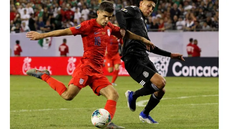 Christian Pulisic of the United States shakes of Edson Alvarez of Mexico and shoots (Getty)