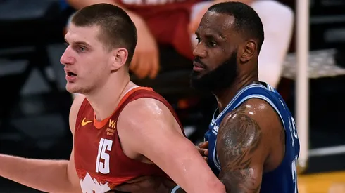 Nikola Jokic #15 of the Denver Nuggets is guarded by LeBron James #23 of the Los Angeles Lakers during the first half at Staples Center.
