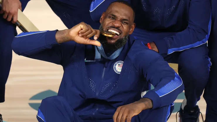 Gold medalist LeBron James of Team United States bites his medal while posing for a photo during the Men's basketball medal ceremony