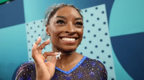 Gold medalist Simone Biles of Team United States poses with a necklace in the likeness of a goat after competing in the Artistic Gymnastics Women's All-Around Final.