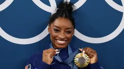 Gold medalist Simone Biles of Team United States poses with the Olympic Rings and a goat charm on her necklace during the Artistic Gymnastics Women's All-Around Final.