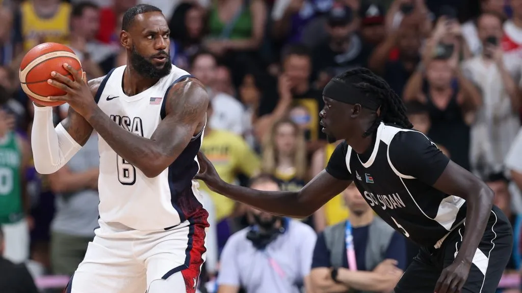 Lebron James #6 of Team United States holds the ball while defended by Nuni Omot #5 of Team South Sudan during a Menās Group Phase ā Group C game between United States and South Sudan on day five of the Olympic Games Paris 2024 at Stade Pierre Mauroy on July 31, 2024 in Lille, France. (Photo by Gregory Shamus/Getty Images)