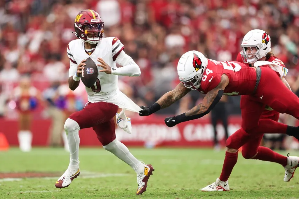 GLENDALE, ARIZONA – SEPTEMBER 29: Jayden Daniels #5 of the Washington Commanders scrambles to avoid a sack by Xavier Thomas #54 of the Arizona Cardinals during the second half at State Farm Stadium on September 29, 2024 in Glendale, Arizona. (Photo by Christian Petersen/Getty Images)