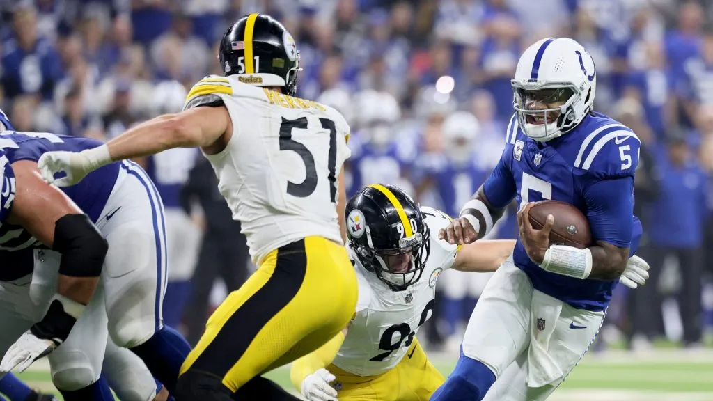 Anthony Richardson (5) of the Indianapolis Colts scrambles against T.J. Watt (90) of the Pittsburgh Steelers during the first quarter at Lucas Oil Stadium on September 29, 2024 in Indianapolis, Indiana.