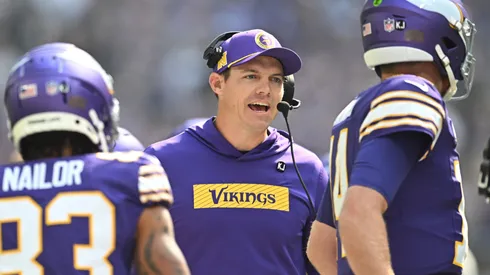 Kevin O'Connell, head coach of the Minnesota Vikings, speaks to quarterback Sam Darnold #14 during the first quarter against the Houston Texans at U.S. Bank Stadium on September 22, 2024 in Minneapolis, Minnesota.