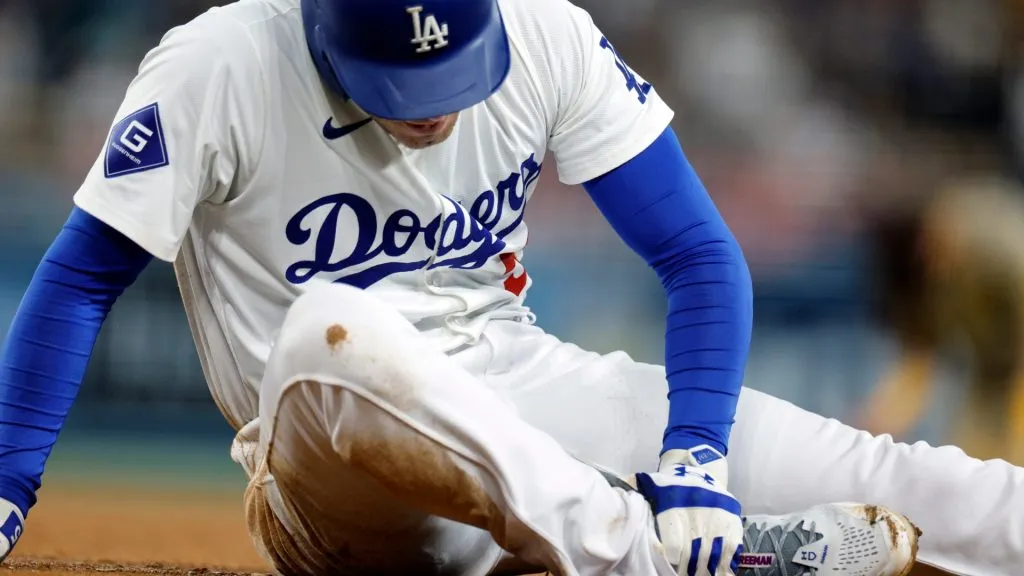 reddie Freeman #5 of the Los Angeles Dodgers holds his right ankle after an injury running from home plate to first base on a ground out against first baseman Luis Arraez #4 of the San Diego Padres during the seventh inning at Dodger Stadium on September 26, 2024 in Los Angeles, California. (Photo by Kevork Djansezian/Getty Images)