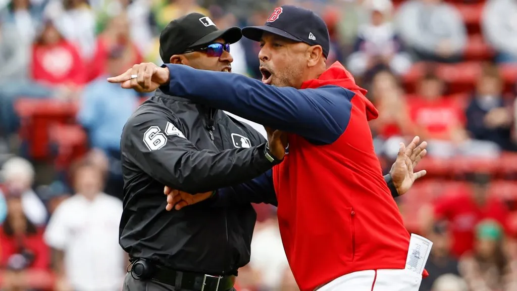 Manager Alex Cora #13 of the Boston Red Sox is held back by umpire Alan Porter #64 after he got thrown out of the game for arguing after the umpires ruled a Red Sox infielder had blocked the base trying to tag a Minnesota Twins runner out during the first inning of game one of a doubleheader at Fenway Park. (Photo By Winslow Townson/Getty Images)