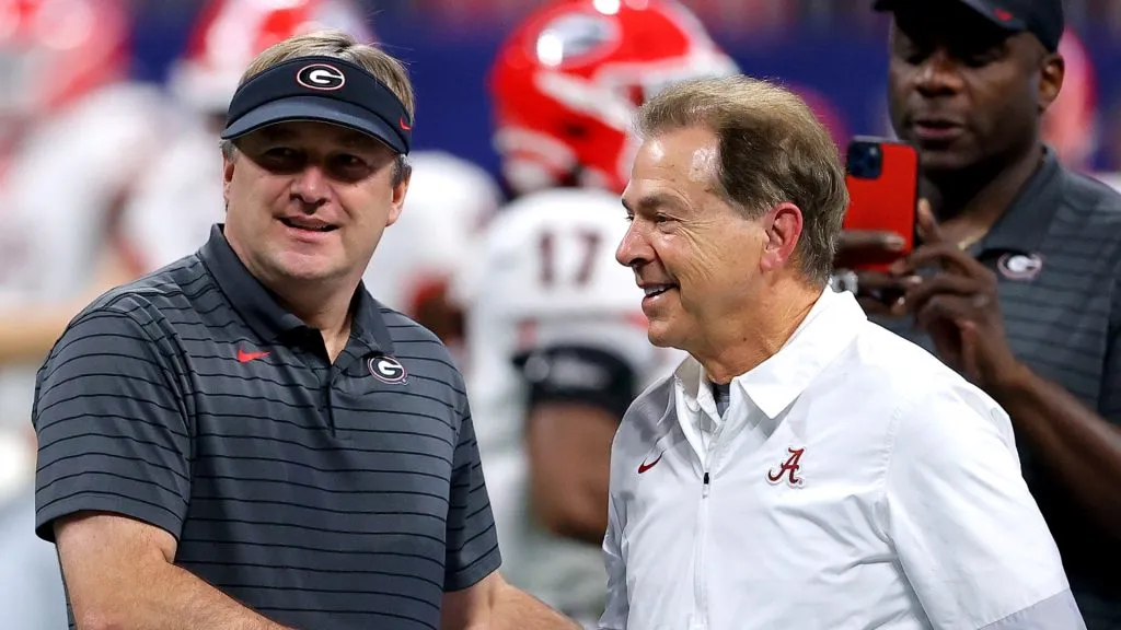 Head Coach Nick Saban of the Alabama Crimson Tide talks with Head Coach Kirby Smart of the Georgia Bulldogs before the SEC Championship game at Mercedes-Benz Stadium on December 04, 2021 in Atlanta, Georgia.