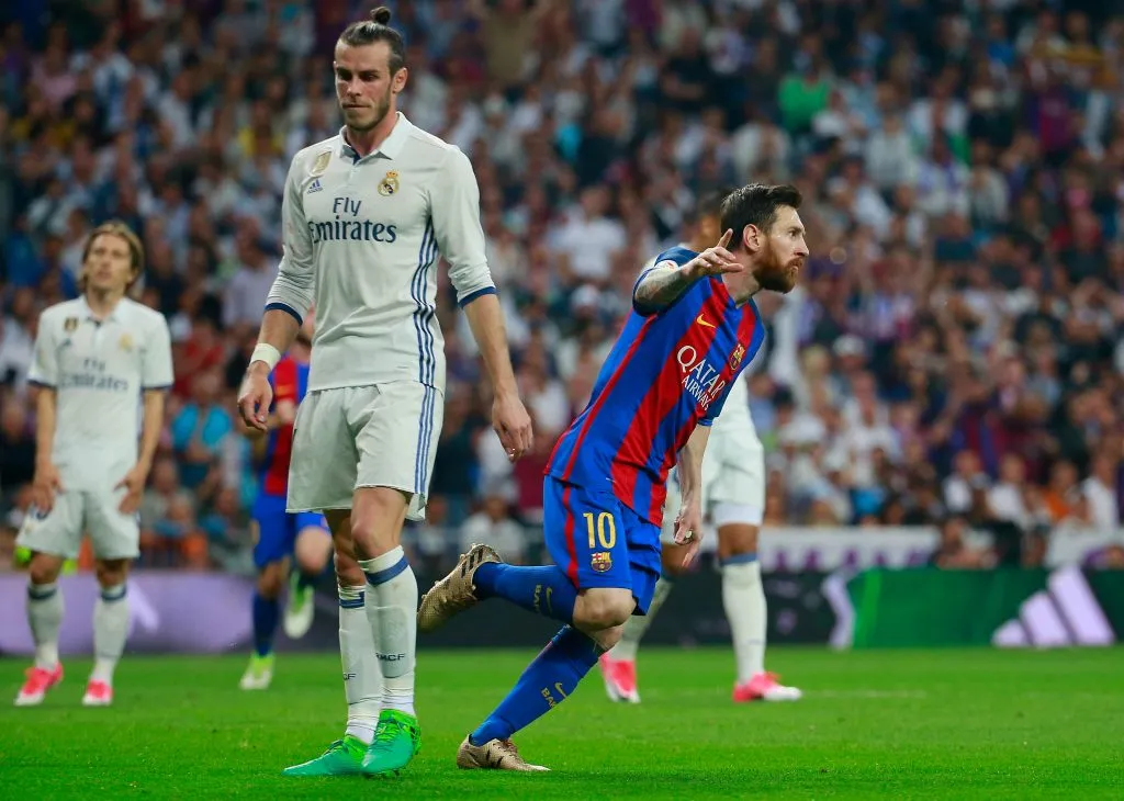 MADRID, SPAIN – APRIL 23:  Lionel Messi of Barcelona celebrates as he scores their first and equalising goal as Gareth Bale of Real Madrid looks dejected during the La Liga match between Real Madrid CF and FC Barcelona .