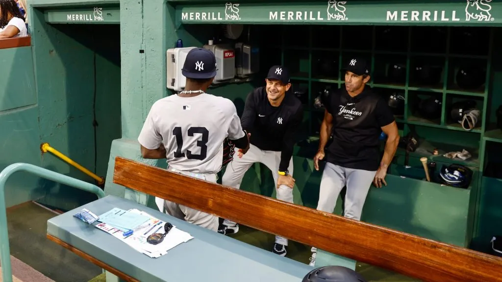 Aaron Boone #17 of the New York Yankees greets newly acquired player Jazz Chisholm Jr. #13 as Chisholm enters the dugout before their game against the Boston Red Sox at Fenway Park. (Photo By Winslow Townson/Getty Images)