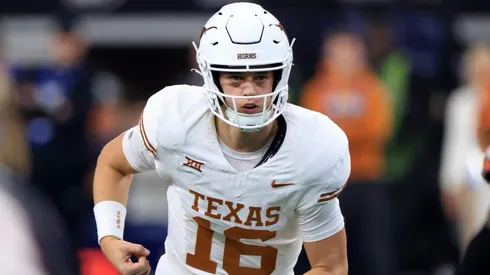 Quarterback Arch Manning #16 of the Texas Longhorns runs behind the line against the Oklahoma State Cowboys in the second half of the Big 12 Championship at AT&T Stadium on December 2, 2023 in Arlington, Texas.