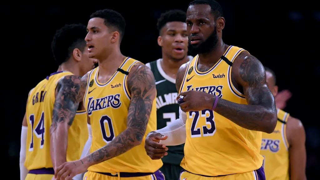 LeBron James #23 and Kyle Kuzma #0 of the Los Angeles Lakers react after a James score, in front of Giannis Antetokounmpo #34 of the Milwaukee Bucks during a 113-103 Laker win at Staples Center on March 06, 2020 in Los Angeles, California.