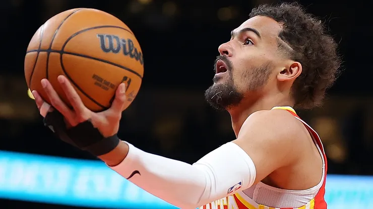Trae Young #11 of the Atlanta Hawks drives to the basket against Tre Mann #23 of the Charlotte Hornets during the first quarter at State Farm Arena on April 10, 2024 in Atlanta, Georgia.