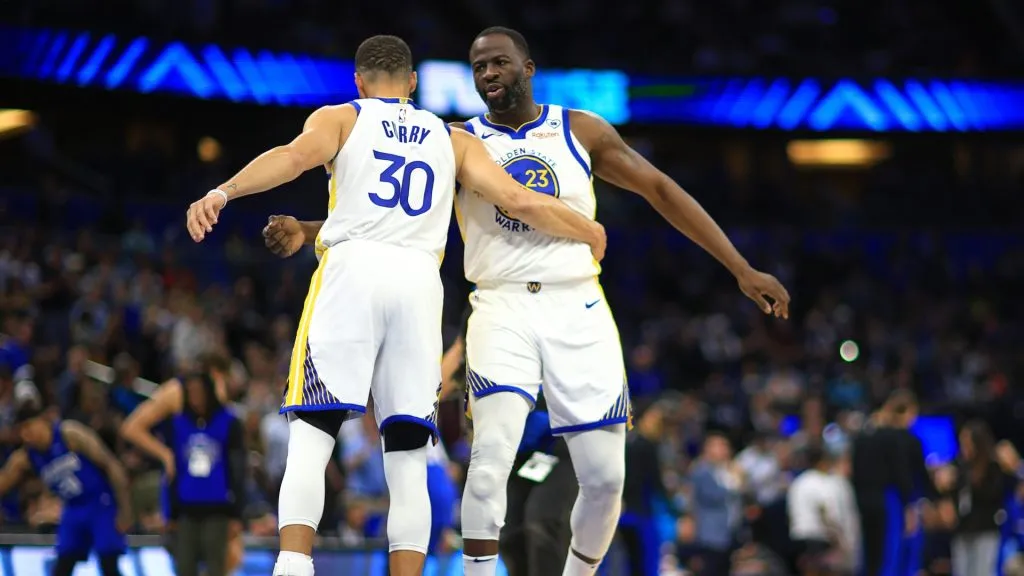 Stephen Curry #30 and Draymond Green #23 of the Golden State Warriors shake hands during a game against the Orlando Magic at Kia Center on March 27, 2024 in Orlando, Florida. 
