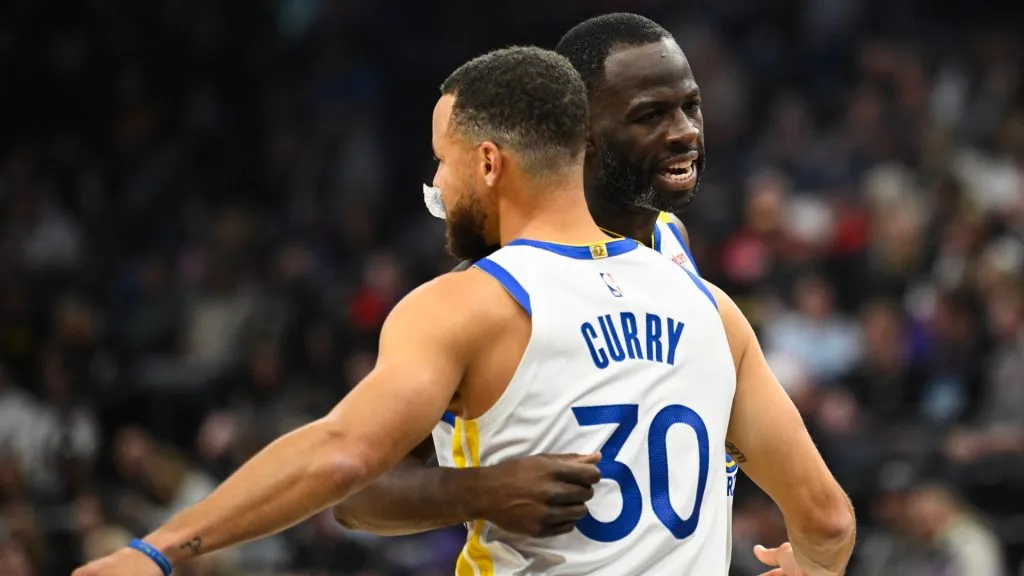 Draymond Green #23 hugs Stephen Curry #30 of the Golden State Warriors during the first half of a game against the Utah Jazz at Delta Center on October 25, 2024 in Salt Lake City, Utah. 
