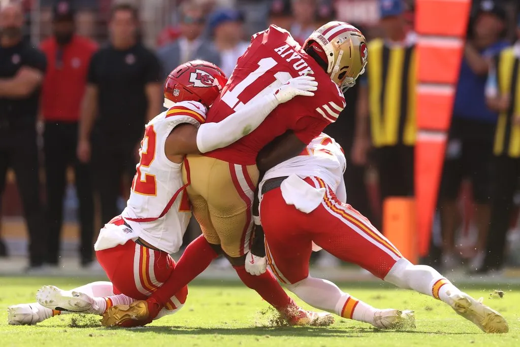 SANTA CLARA, CALIFORNIA – OCTOBER 20: Brandon Aiyuk #11 of the San Francisco 49ers is hit by Trent McDuffie #22 and Chamarri Conner #27 of the Kansas City Chiefs during the second quarter at Levi’s Stadium on October 20, 2024 in Santa Clara, California. (Photo by Ezra Shaw/Getty Images)