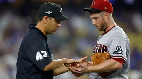 Umpire Gabe Morales inspects the hands of Merrill Kelly #29 of the Arizona Diamondbacks after Kelly was relieved in the seventh inning against the Los Angeles Dodgers during Game One of the Division Series at Dodger Stadium on October 07, 2023 in Los Angeles, California.
