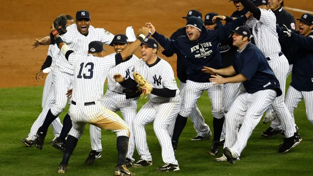 Mariano Rivera #42 and Mark Teixeira #25 of the New York Yankees run towards Alex Rodriguez #13 and his teammates as they celebrate after their 7-3 win against the Philadelphia Phillies in Game Six of the 2009 MLB World Series at Yankee Stadium on November 4, 2009 in the Bronx borough of New York City. (Photo by Chris McGrath/Getty Images)