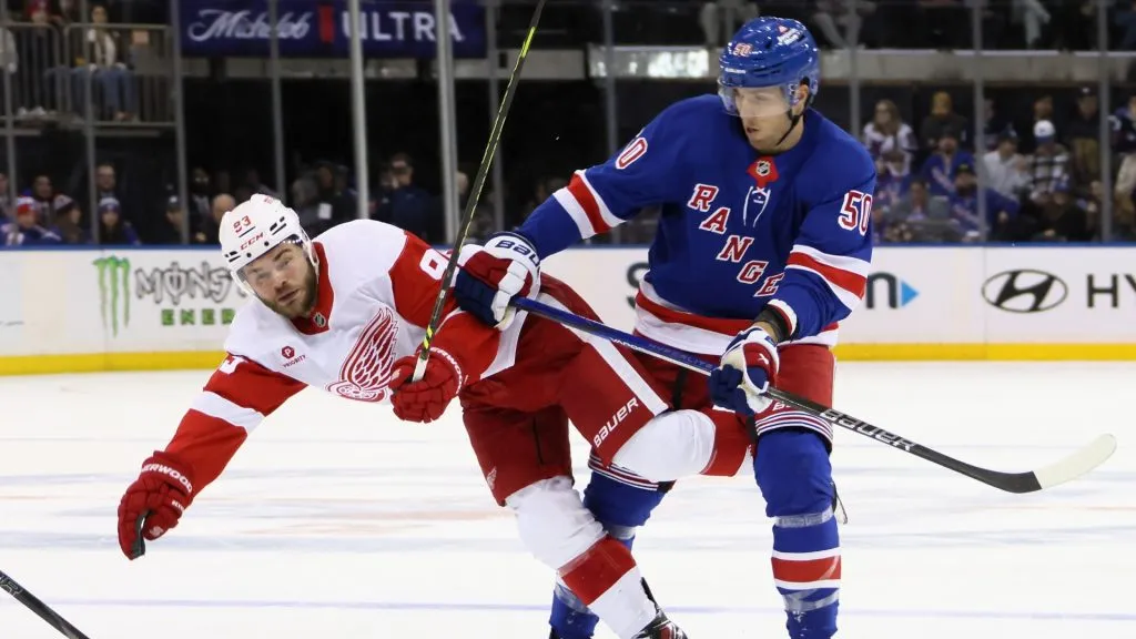 : Will Cuylle #50 of the New York Rangers checks Alex DeBrincat #93 of the Detroit Red Wings during the third period at Madison Square Garden on October 14, 2024 in New York City. The Rangers defeated the Red Wings 4-1. (Photo by Bruce Bennett/Getty Images)