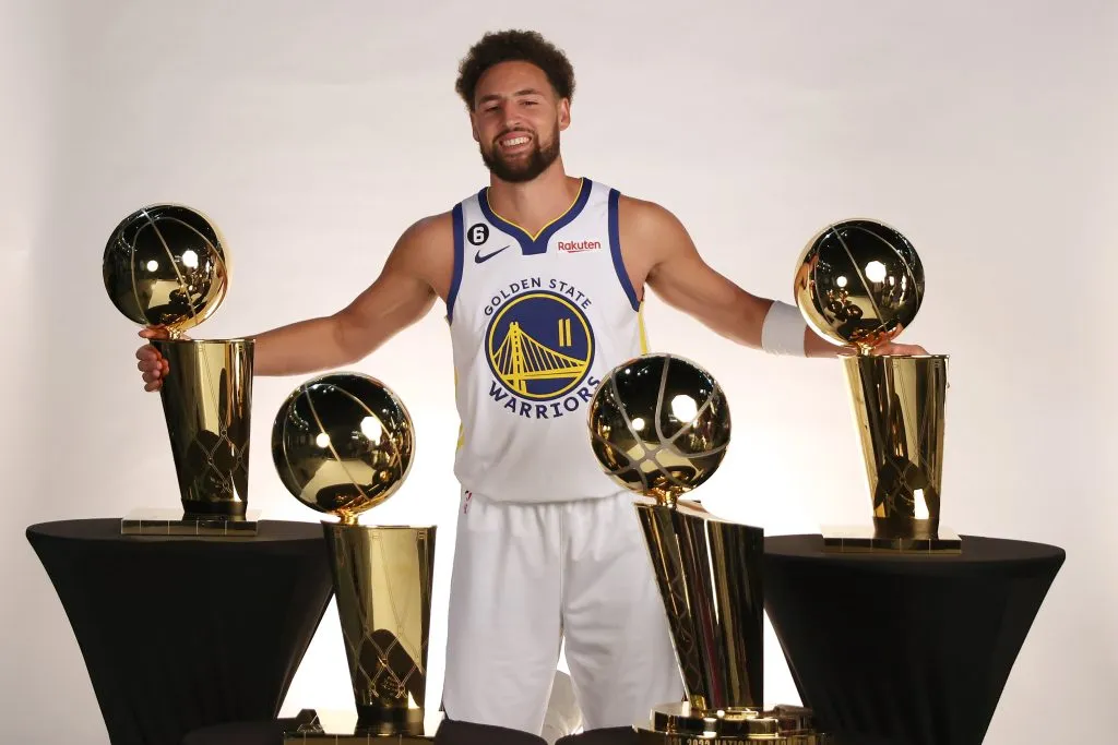 Klay Thompson #11 of the Golden State Warriors poses with the four Larry O’Brien Championship Trophies that he has won with the  Warriors. Ezra Shaw/Getty Images
