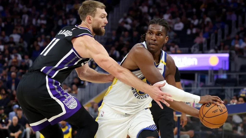 Kevon Looney #5 of the Golden State Warriors is guarded by Domantas Sabonis #11 of the Sacramento Kings during the second half of their preseason game at Chase Center on October 11, 2024 in San Francisco, California.