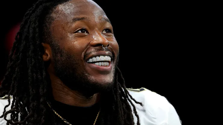 Alvin Kamara (41) of the New Orleans Saints smiles showing his diamond grill before a game against the Atlanta Falcons at Mercedes-Benz Stadium on September 29, 2024 in Atlanta, Georgia.