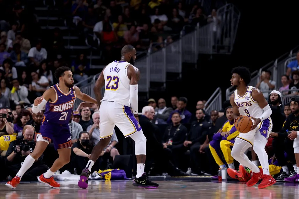 LeBron James #23 of the Los Angeles Lakers sets a screen for Bronny James #9 against Tyus Jones #21 of the Phoenix Suns. Katelyn Mulcahy/Getty Images
