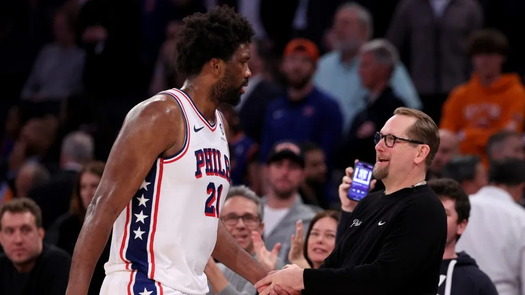 Joel Embiid #21 of the Philadelphia 76ers heads for the bench as he is greeted by Nick Nurse in the overtime period against the New York Knicks at Madison Square Garden on April 30, 2024 in New York City. The Philadelphia 76ers defeated the New York Knicks 112-106 in overtime.