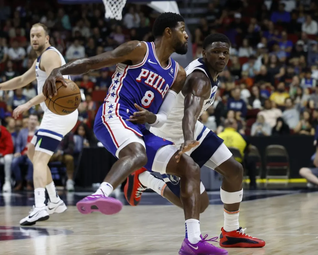 Paul George #8 of the Philadelphia 76ers drives the ball as Anthony Edwards #5 of the Minnesota Timberwolves puts pressure on him. David Purdy/Getty Images