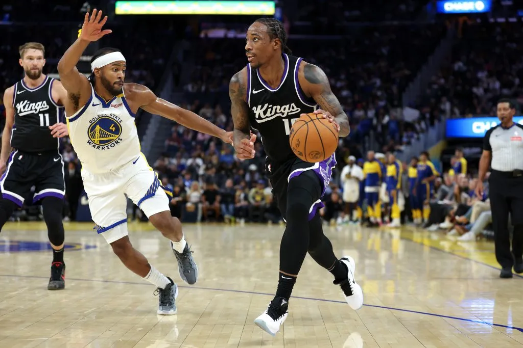 DeMar DeRozan #10 of the Sacramento Kings is guarded by Moses Moody #4 of the Golden State Warriors during the first half of their preseason game. Ezra Shaw/Getty Images