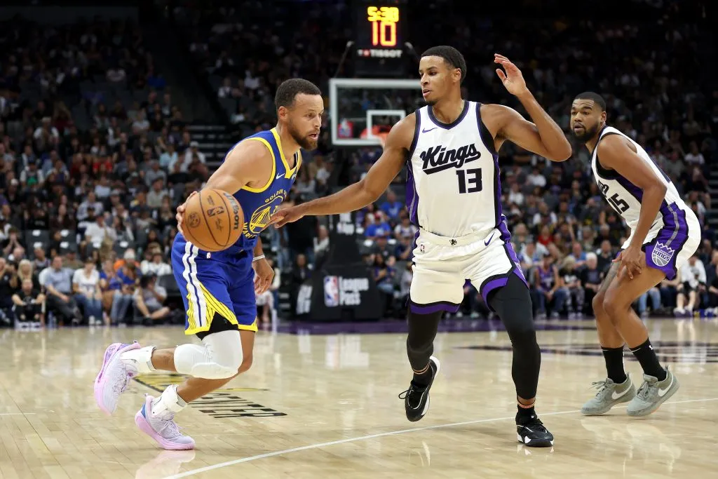 Stephen Curry #30 of the Golden State Warriors is guarded by Keegan Murray #13 and Mason Jones #15 of the Sacramento Kings during their preseason game Ezra Shaw/Getty Images