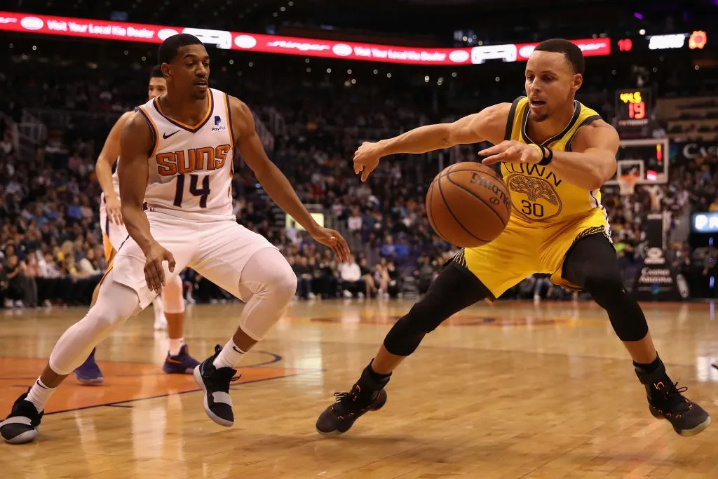 Stephen Curry #30 of the Golden State Warriors controls the ball ahead of De’Anthony Melton #14 of the Phoenix Suns. Christian Petersen/Getty Images