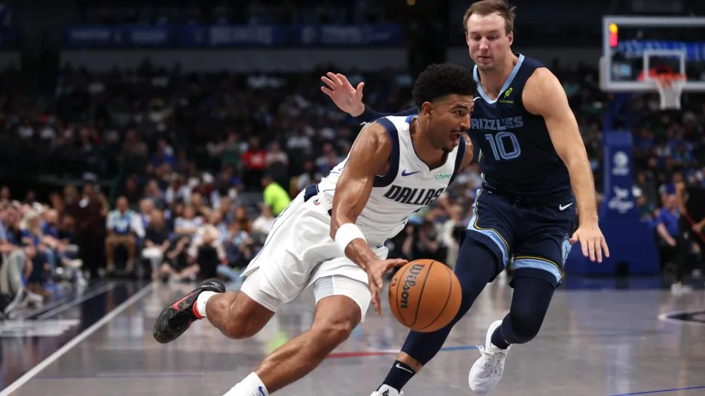 Quentin Grimes #5 of the Dallas Mavericks drives around Luke Kennard #10 of the Memphis Grizzlies in the first half of a pre-season game at American Airlines Center on October 7, 2024 in Dallas, Texas.