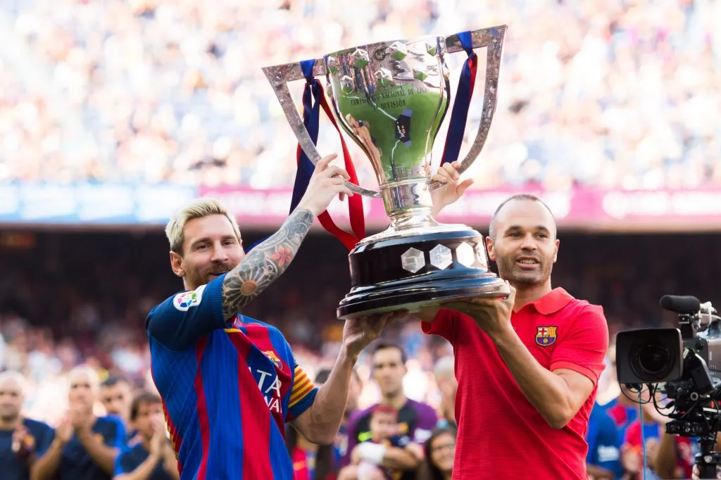 Lionel Messi (L) and Andres Iniesta (R) of FC Barcelona lift up the Spanish La Liga 2015-2016 season trophy. Alex Caparros/Getty Images
