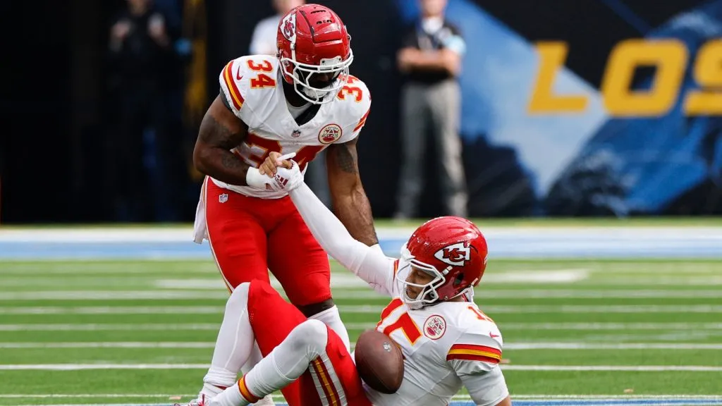 Samaje Perine #34 of the Kansas City Chiefs helps Patrick Mahomes #15 up after being sacked during the second quarter against the Los Angeles Chargers at SoFi Stadium on September 29, 2024 in Inglewood, California.