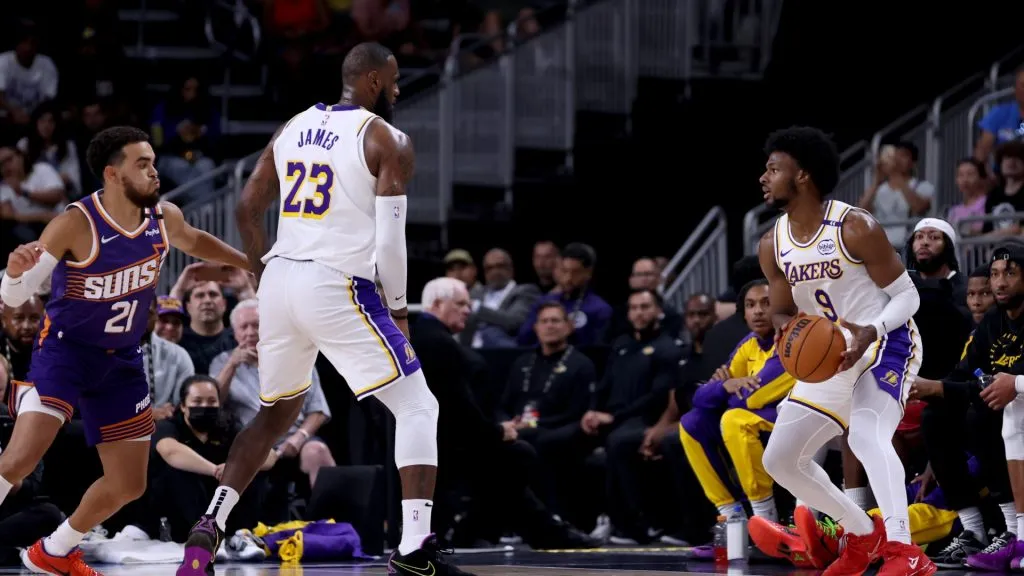 LeBron James #23 of the Los Angeles Lakers sets a screen for Bronny James #9 against Tyus Jones #21 of the Phoenix Suns during the second quarter at Acrisure Arena on October 06, 2024 in Palm Springs, California.