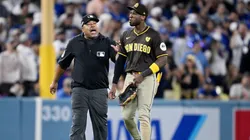 Jurickson Profar #10 of the San Diego Padres walks across the field escorted by umpire Adrian Johnson after an incident with fans in the seventh inning against the Los Angeles Dodgers during Game Two of the Division Series at Dodger Stadium on October 06, 2024 in Los Angeles, California. (Photo by Orlando Ramirez/Getty Images)