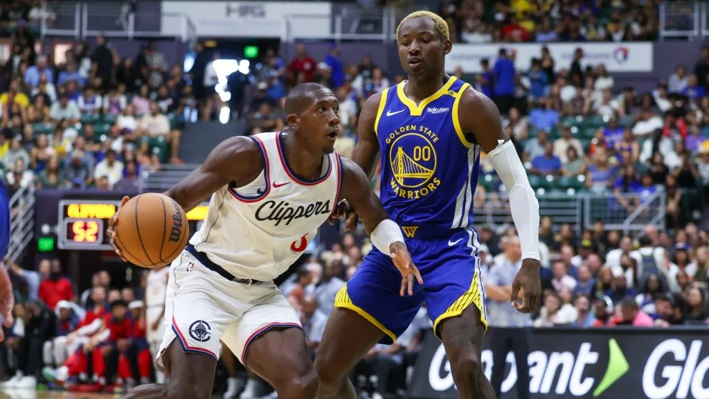 Kris Dunn #8 of the LA Clippers drives around Jonathan Kuminga #0 of the Golden State Warriors during the second half of an exhibition game at SimpliFi Arena on October 5, 2024 in Honolulu, Hawaii.