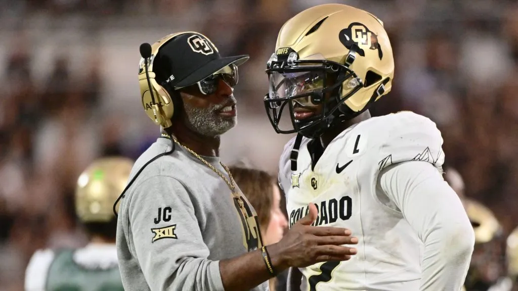Head coach Deion Sanders of the Colorado Buffaloes talks with Shedeur Sanders #2 during the second half of a game against the UCF Knights at FBC Mortgage Stadium on September 28, 2024 in Orlando, Florida.