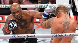 Mike Tyson (L) punches Jake Paul during their heavyweight bout at AT&T Stadium on November 15, 2024 in Arlington, Texas.