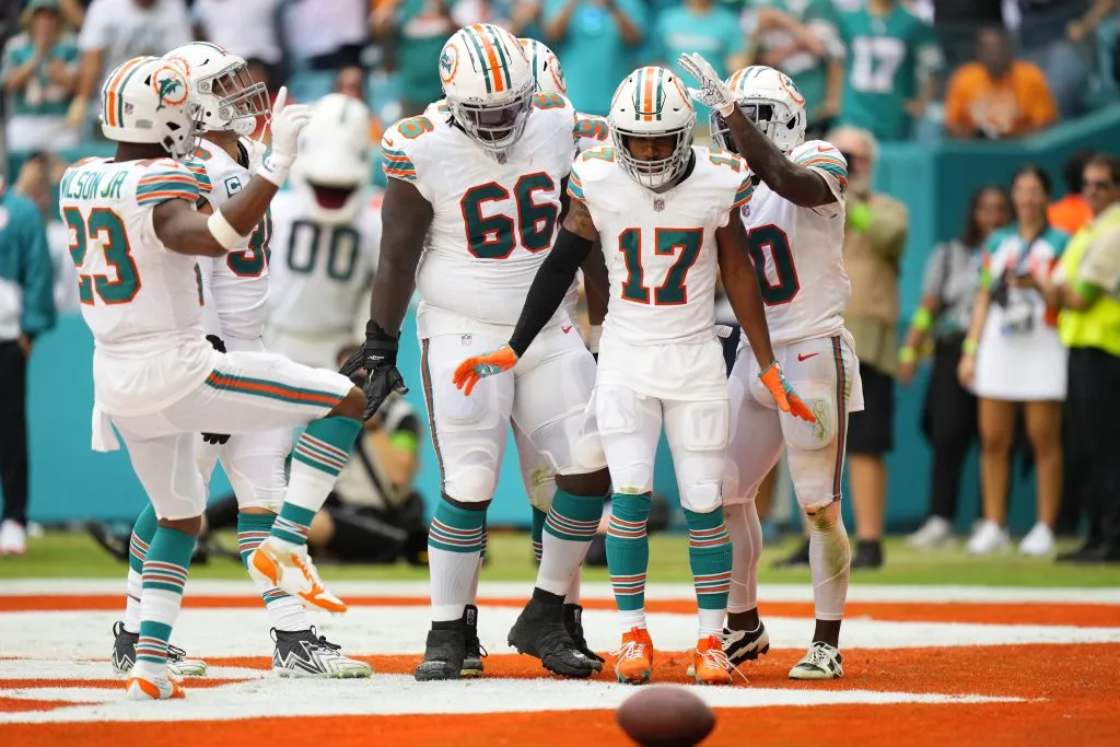 Lester Cotton #66 of the Miami Dolphins and Tyreek Hill #10 of the Miami Dolphins celebrate with Jaylen Waddle #17 of the Miami Dolphins